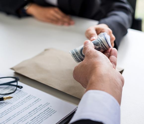 Mano cortada de un cliente dando papel moneda un hombre de negocios en la oficina